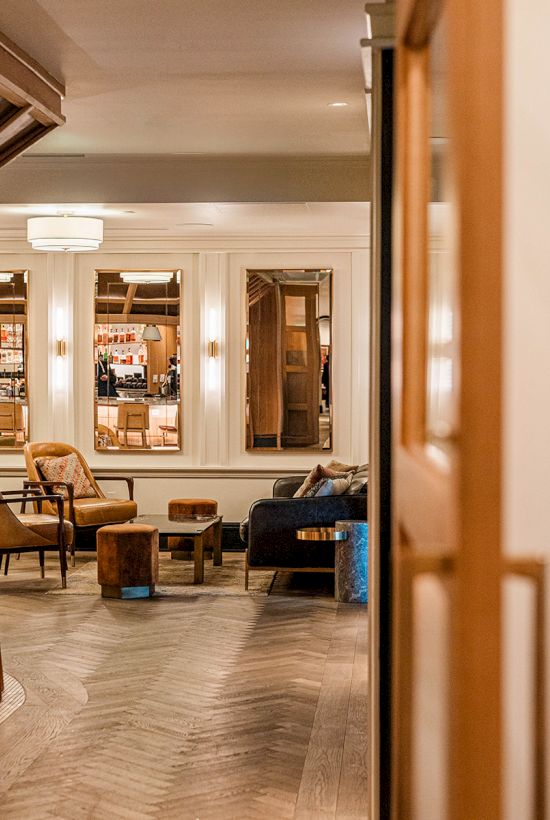 A cozy clubhouse interior with a bar area, seating, warm lighting, and a door labeled &ldquo;Clayton Members Club,&rdquo; inviting and stylish.