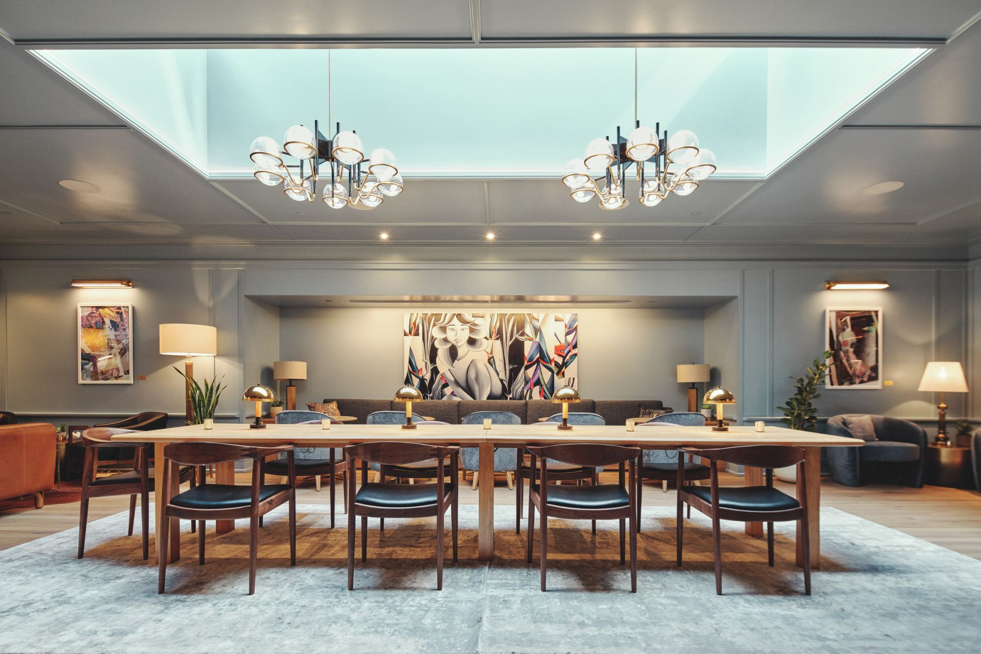 A modern dining room with a large table, chairs, stylish lighting, art on the walls, and cozy seating in the background completes the scene.