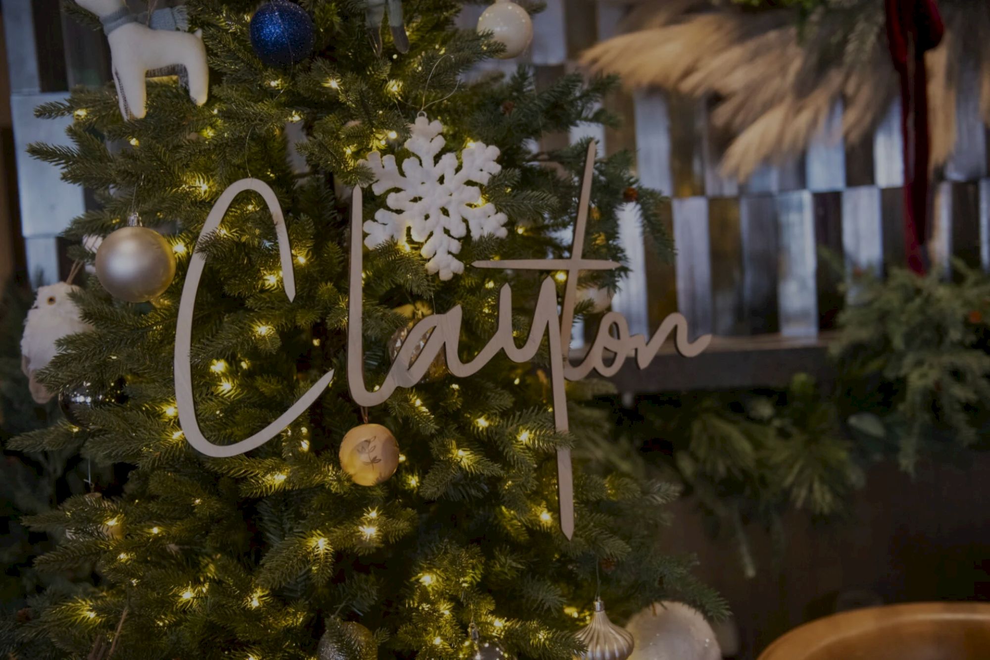 A decorated Christmas tree with ornaments, lights, and a sign that looks like it says "Clárton," along with a snowflake decoration.