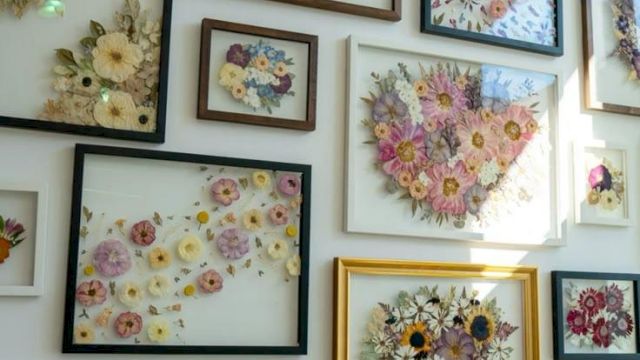 A wall filled with framed floral arrangements, many bouquets in pastel tones, arranged in varied frame sizes and styles.