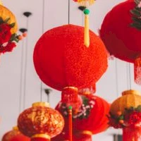 Colorful Chinese lanterns hanging from the ceiling, bright red and orange, with tassels and floral decorations, festive and decorative.